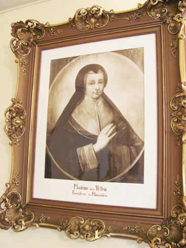 Carved golden frame. Sketch of Madeleine de la Peltrie, in widow clothes. Turned to the right. Joint hands to pray.