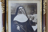 Black and gold frame. Portrait drawn. Mary of the Incarnation, in a religious habit, turned to the right. Hands open at the front pointing towards the sky. Look at the sky. Behind, an open book.