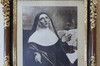 Cadre noir et or. Portrait dessiné. Marie de l’Incarnation, en habit religieux, tournée vers la droite. Mains ouvertes à l’avant pointant vers le ciel. Regard au ciel. Derrière, un livre ouvert.