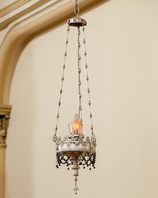 Lampe suspendue, argentée, découpée comme de la dentelle, décorée de chaines de billes noires. Flamme artificielle.