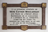 Commemorative plaque fixed of the wall. Tribute to mother Esther Wheelwright. Black letter text on white marble. Brown contour, with letters on  gilded backgrounds.