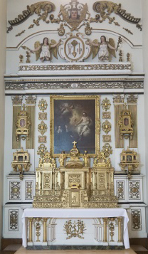 White altar table with gilded low relief. On it, the tabernacle and the gilded altarpiece are surrounded by low reliefs and pediment. At the centre, a painting of Jesus offering his heart to a group of nuns.