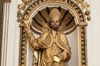 Statue of St. Augustine. Golden. In a decorated alcove.