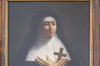 Painted portrait of Marie de st-Joseph de la Troche, in nun clothes, crossed hands on her heart. Holding a wooden cross.