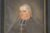Tableau peint. Cadre de bois noir. Portrait de Monseigneur Plessis dans son habit religieux. Cheveux gris, sans sourire, regard vers la gauche.