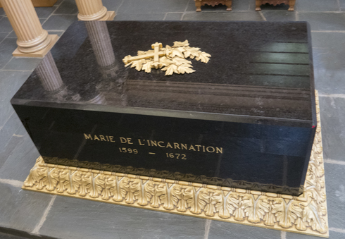 Block of black marble. Gilded engraved on the sides: « Marie de l’Incarnation 1599-1672 ». Ornated and golden base. Leaves and ornament above.