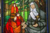 Rectangular colorful Stained-glass window. Arched top. Illustration of Marie of the incarnation teacher under an ash tree.